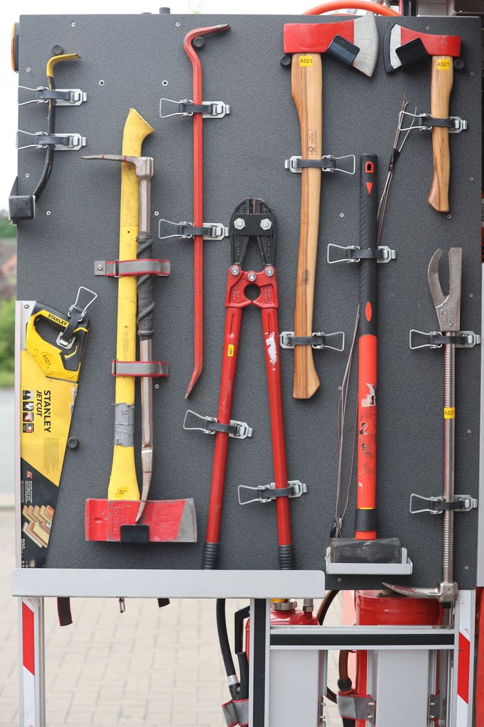Über Uns Collection of firefighter tools neatly arranged on a board for easy access.